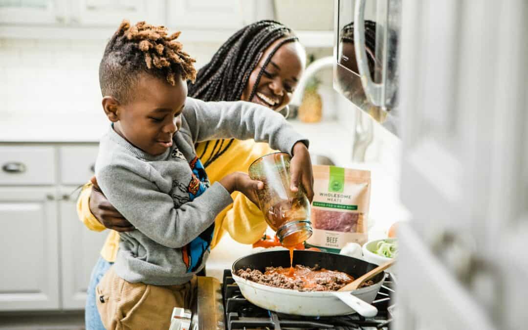boy cooking with mom demonstrating the learning of basic life skills
