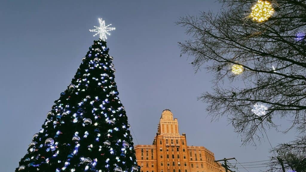 a large christmas tree in front of a building in winter in Arkansas